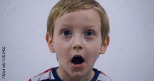 Scared and shocked little boy. Studio shot portrait over white background. Fashionable little boy.
