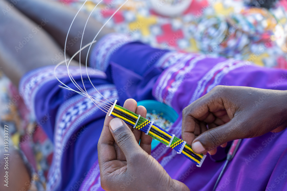 Making of handmade jewellery. Masai african women hands, top view, close up. Island of Zanzibar, Tanzania, Africa - obrazy, fototapety, plakaty 