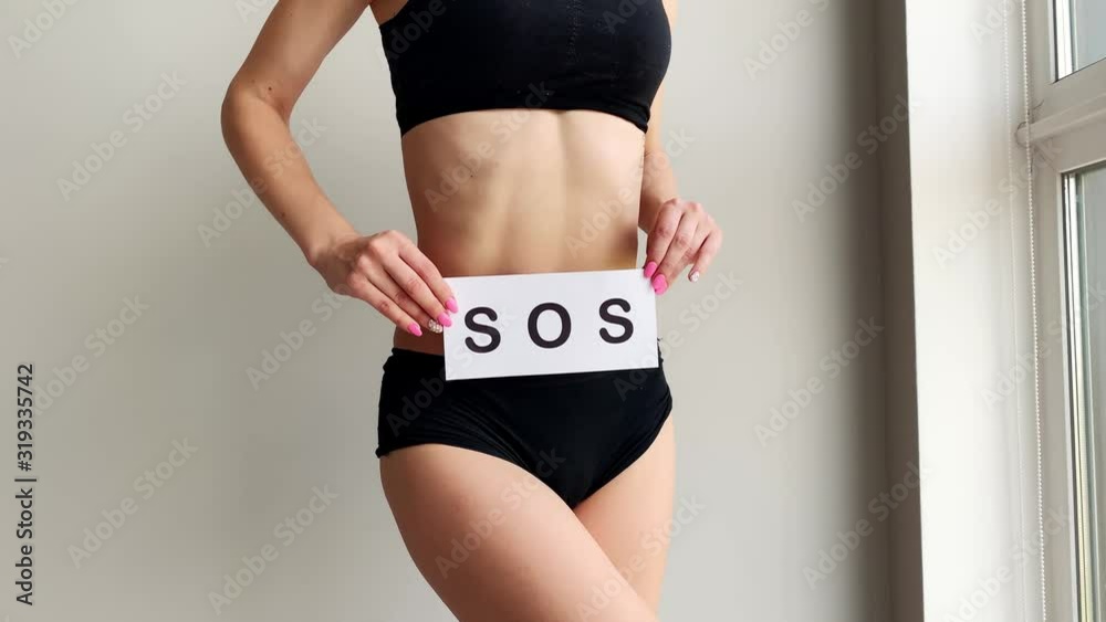 Vaginal or urinary infection and problems concept. Young woman holds paper with sos above crotch