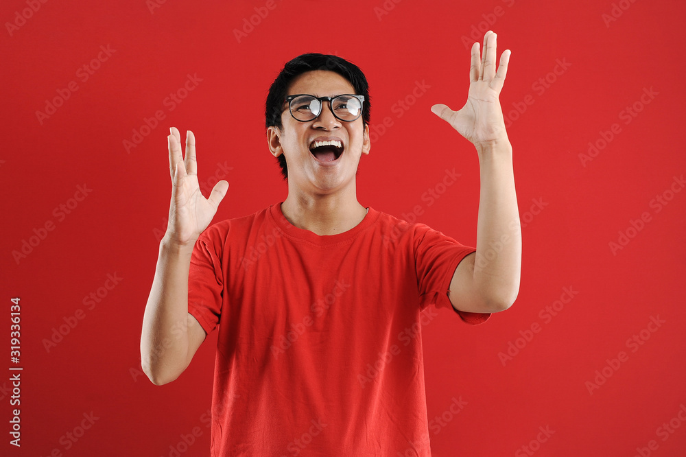 Fototapeta premium Young asian man happy and excited expressing winning gesture. Successful and celebrating