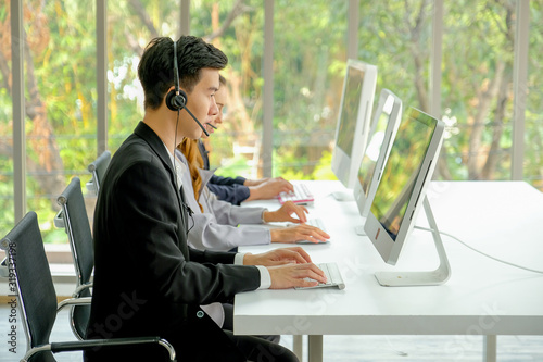 Young man with suit work as operator of the company with different action such as touch headphone or typing.