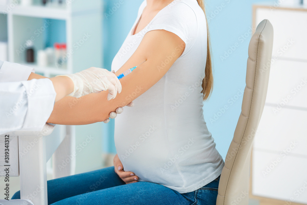Obraz premium Doctor vaccinating pregnant woman in clinic