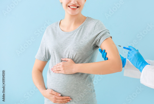 Doctor vaccinating pregnant...