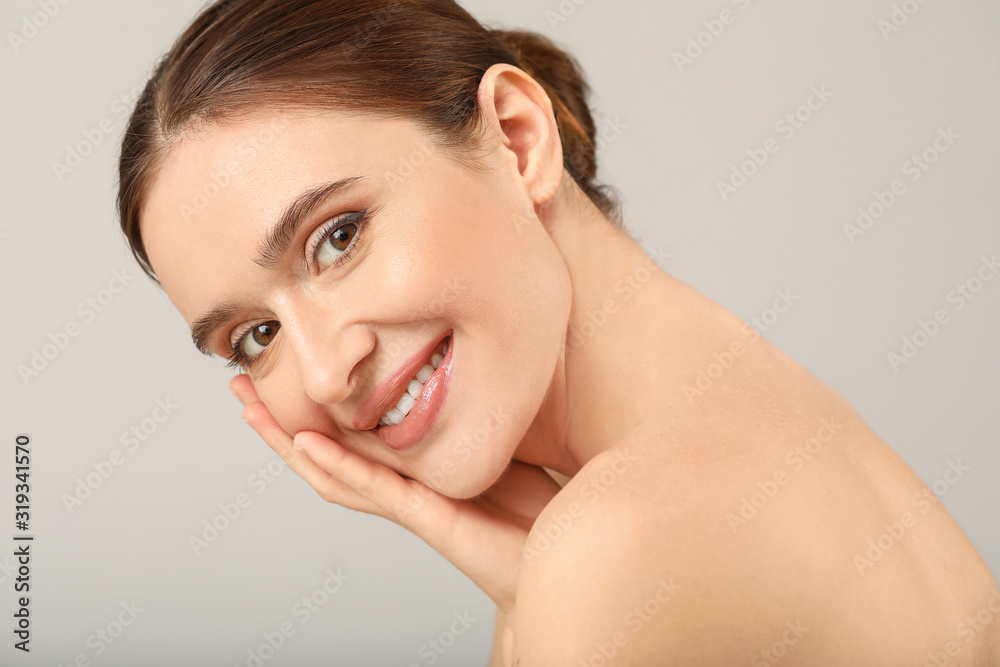 Beautiful young woman with healthy skin on light background Beautiful young woman with healthy skin on light background