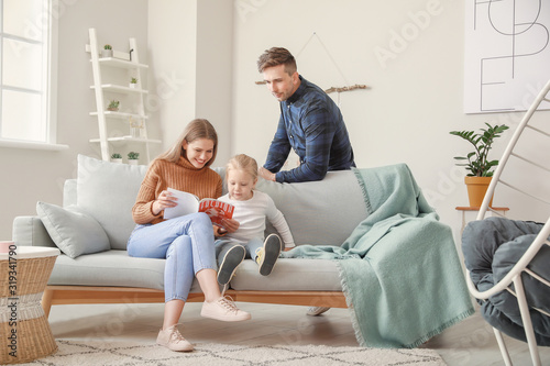 Happy young family reading ...
