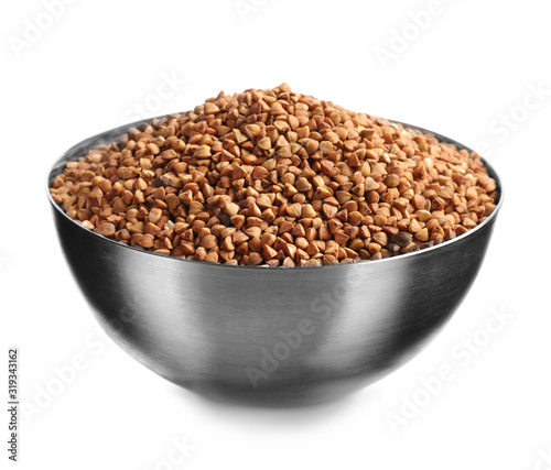 Bowl with raw buckwheat on white background