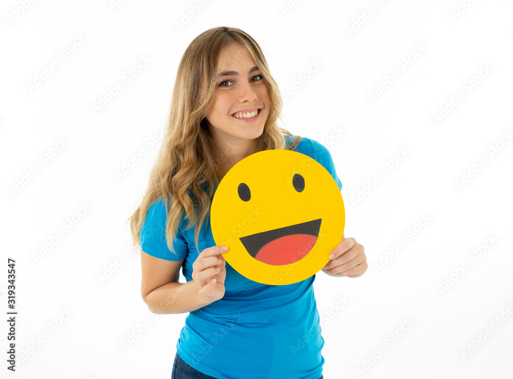 Beautiful young woman holding happy face emoji emoticon social media notification icon. Beautiful young woman holding happy face emoji emoticon social media notification icon.