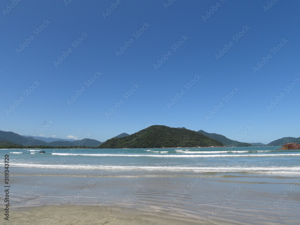 Sea, sand, mountains, sun and blue sky. Beach in the city of Ubatuba. Interior of São Paulo. Brazil.