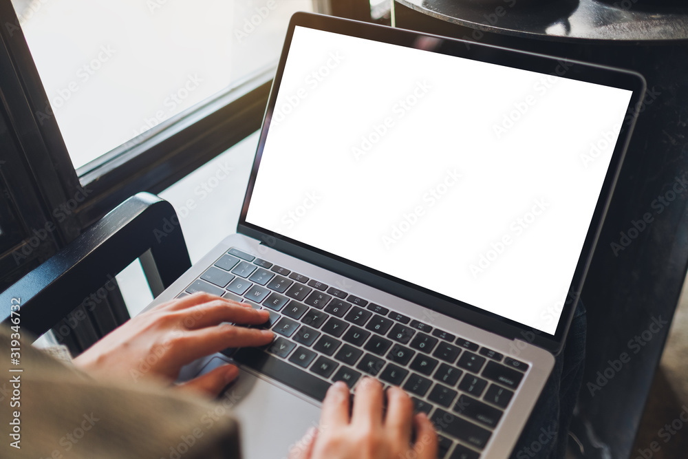 Mockup image of a woman using and typing on laptop computer with blank white desktop screen in cafe Mockup image of a woman using and typing on laptop computer with blank white desktop screen in cafe