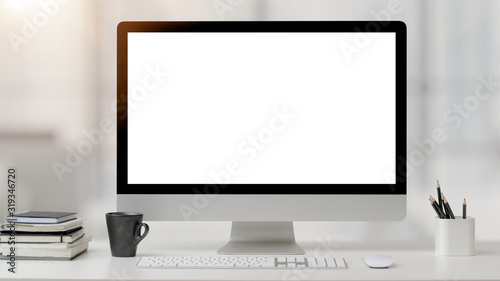 Close up view of office room with computer, office supplies and coffee cup on white desk with blurred background