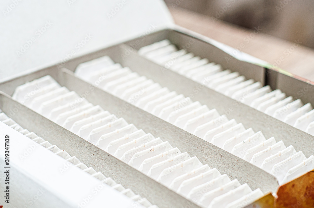 Loose tea bags are tightly packed in rows in a cardboard box. Loose tea bags are tightly packed in rows in a cardboard box.