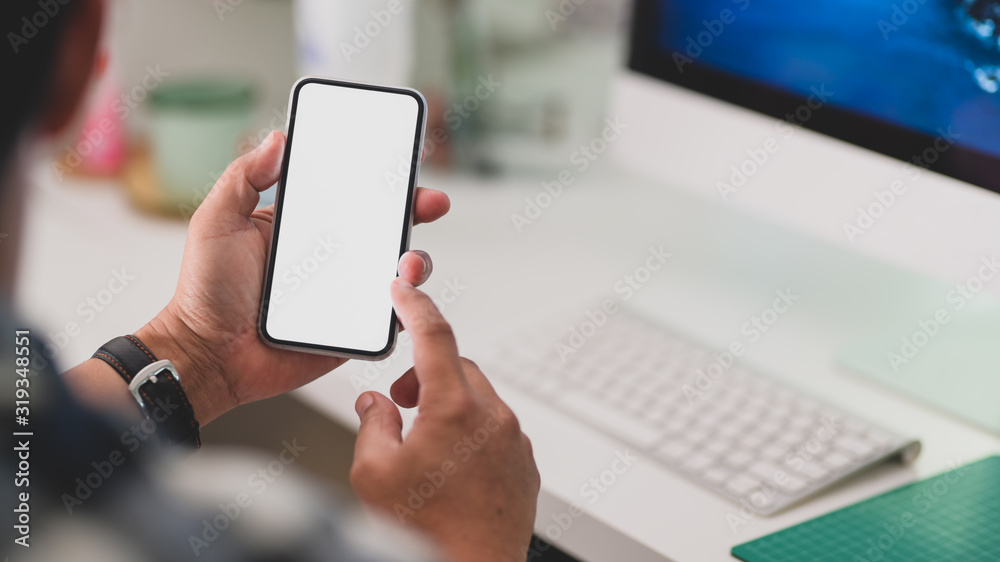 Close up view of a man using blank screen smartphone while working Close up view of a man using blank screen smartphone while working