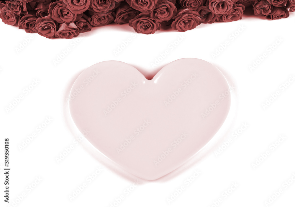 Table setting for Valentine's Day with beautiful red roses and pink plate in the shape of a heart on white background. Close up. Valentines day dinner concept.