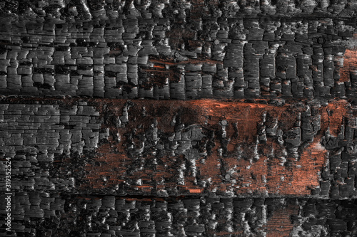 Partially charred wooden boards close up. Burnt wooden board texture. Burned scratched hardwood surface. Dark wood plank background. Burned wooden texture empty horizontal surface, copy space