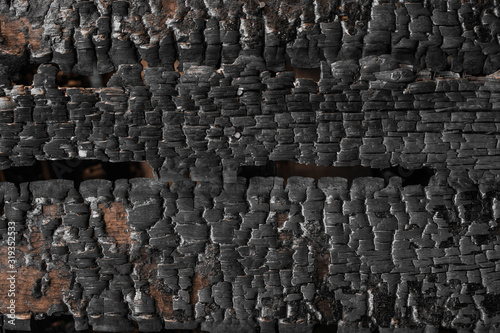 Burnt timber wall. Charred wooden board texture. Burned scratched hardwood surface. Dark burned wooden charcoal texture empty horizontal surface, copy space