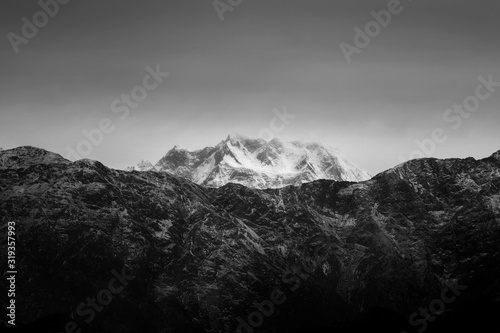 Black and white glacial mountain peak under dark sky