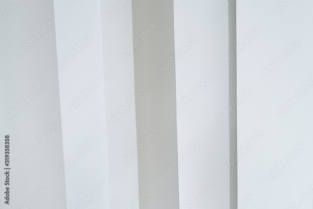 vertical white columns against a white wall