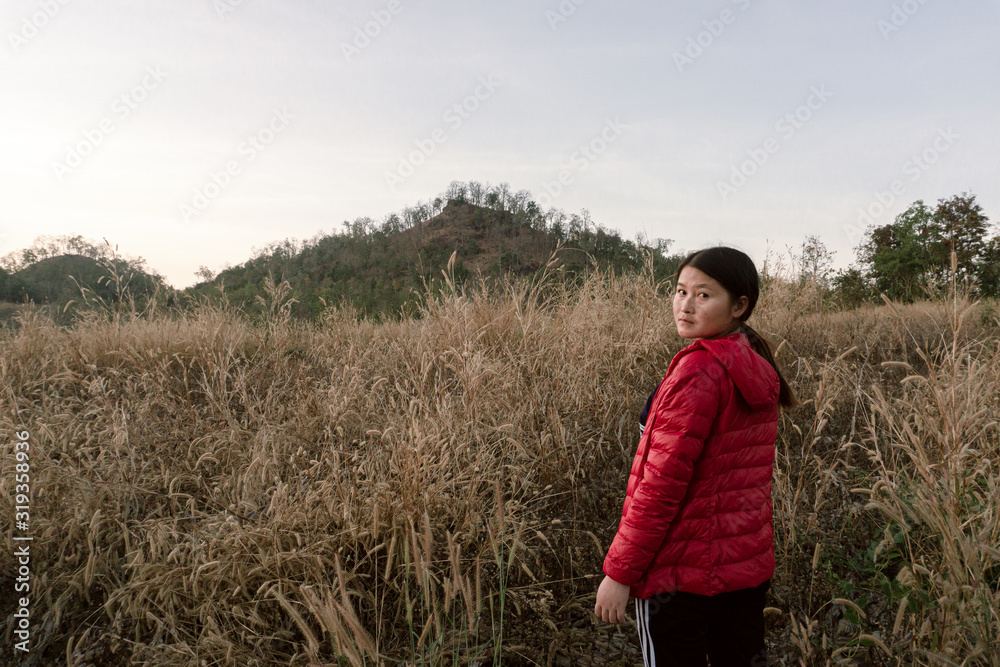 The photo of a girl watching the sunset Flower grass on the hill