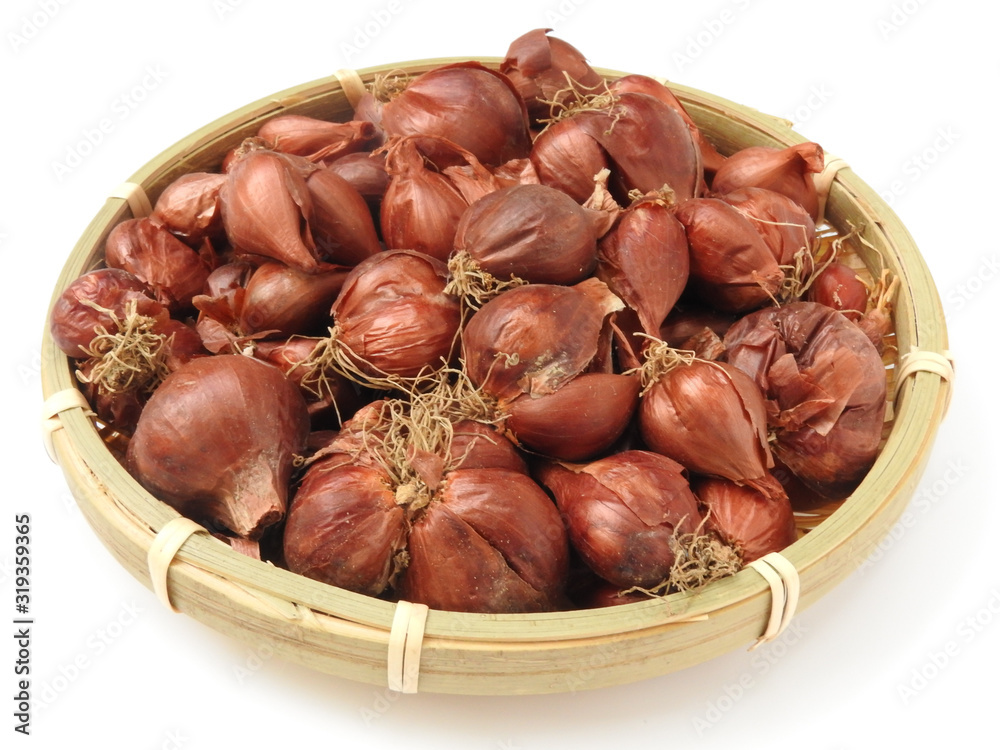 High angle view of natural organic fresh raw red shallot onion on bamboo basket isolated on white background.Taiwan's red onion is water droplets type,skin is red. Food and vegetable concept. High angle view of natural organic fresh raw red shallot onion on bamboo basket isolated on white background.Taiwan's red onion is water droplets type,skin is red. Food and vegetable concept.