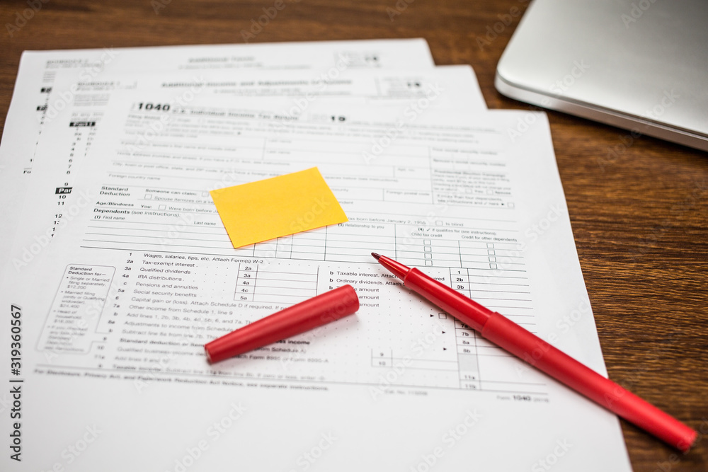 The pen and sticky note are on the tax form 1040 U.S. Individual Income Tax Return. The time to pay taxes. Business concept. The pen and sticky note are on the tax form 1040 U.S. Individual Income Tax Return. The time to pay taxes. Business concept.