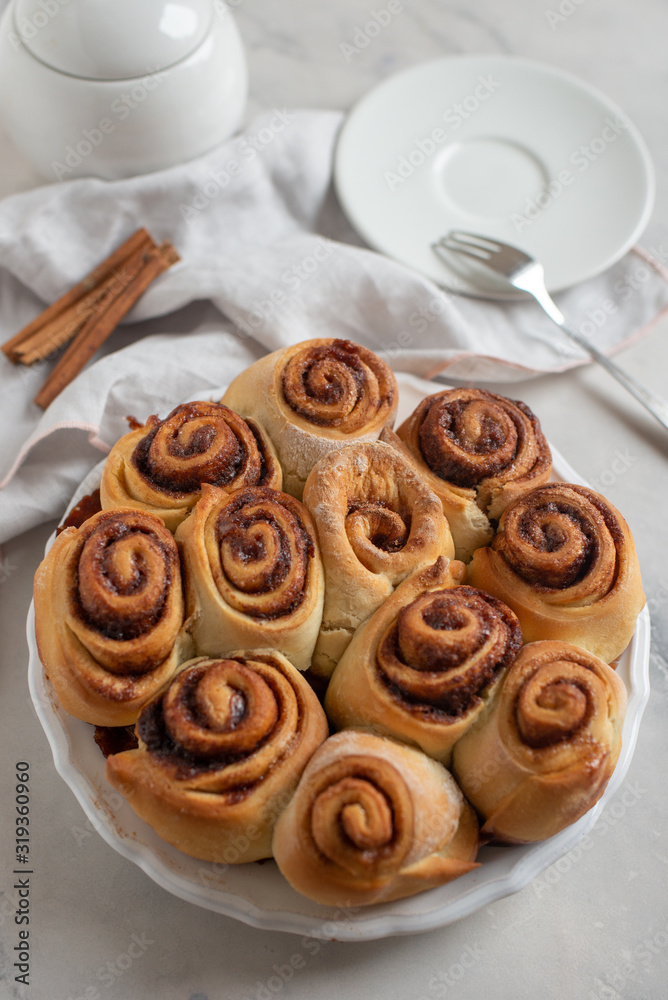 Cinnamon rolls with sugar frosting. With cinnamon sticks and spices, wooden background Cinnamon rolls with sugar frosting. With cinnamon sticks and spices, wooden background