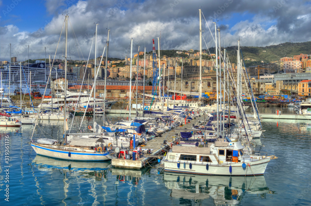 Genoa, Italy - Nov 3th 2013: Boats in Genoa harbor, with HDR effect applied. Clouds and hills in the background.