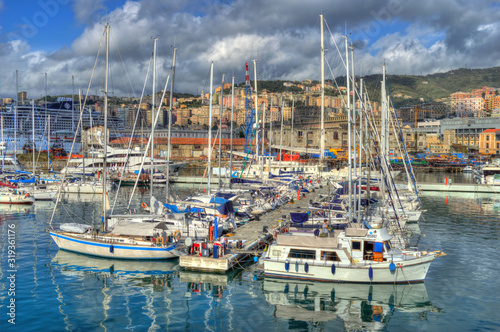 Genoa, Italy - Nov 3th 2013: Boats in Genoa harbor, with HDR effect applied. Clouds and hills in the background.