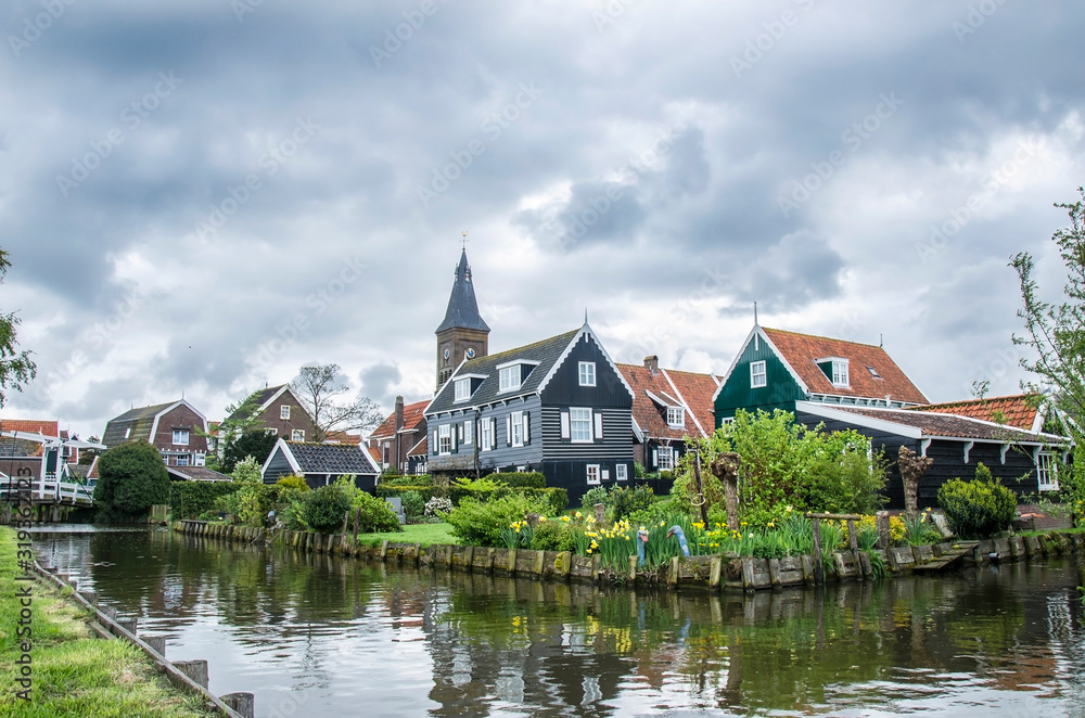 View of canal, bridge and traditional wooden fishing houses in waterland village Marken, Netherlands. Traditional Holland symbols - canal, wooden houses, bridge