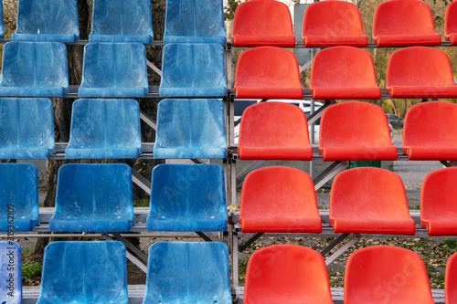 several rows of old blue and red seats on the sports stand