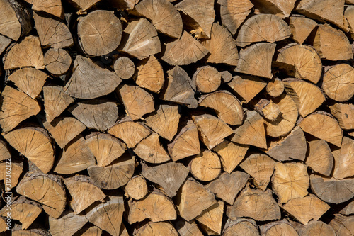 Pile of woods in front of a house. Logs  Fuel for heating. Wooden firewood stacked. Natural wood background