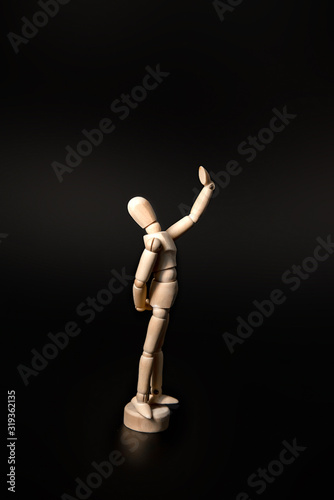 the wooden figure raised its hand high as if looking in a mirror or taking a selfie, proudly admiring itself