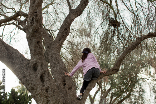 girl climbing on tree in late afternoon