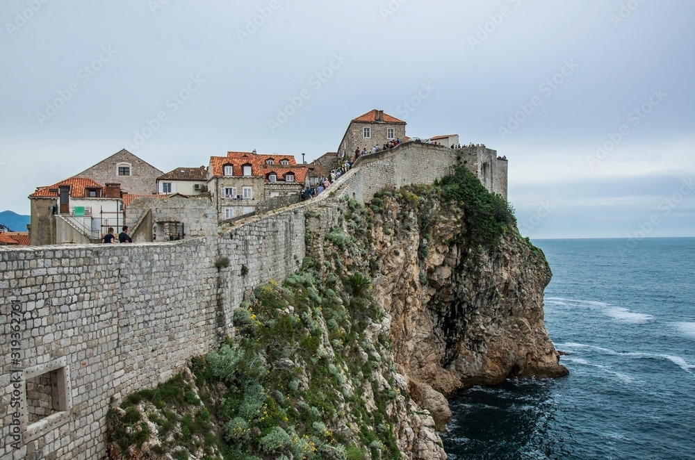 City walls of Dubrovnik Old Town, Croatia. View of the fortress walls, rocky coast and blue sea, Dubrovnik, Croatia