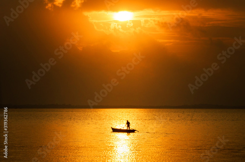 fisherman silhouette and sunset at the sea