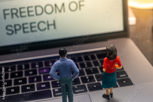 Freedom of Speech Concept - Miniature People looking at a laptop. Shallow depth of field.