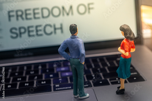 Freedom of Speech Concept - Miniature People looking at a laptop. Shallow depth of field.