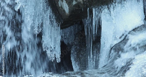 Water flowing under ice in frozen river.
