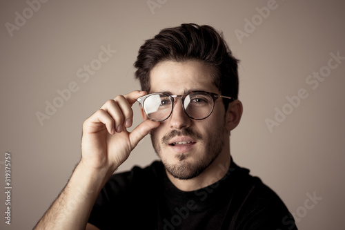 Young attractive latin man with glasses posing looking sensual and handsome. Beauty concept and lifestyle