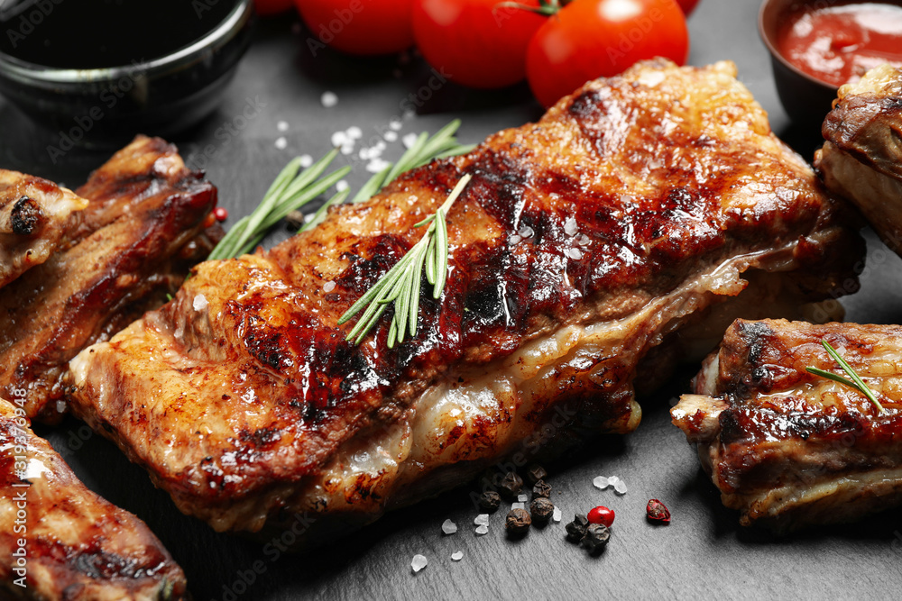 Delicious grilled ribs on slate board, closeup
