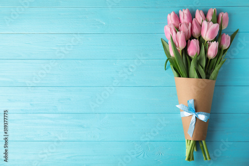 Beautiful pink spring tulips on light blue wooden background, top view. Space for text #319377775