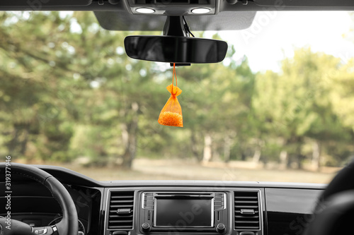 Air freshener hanging on rear view mirror in car