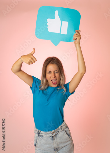 Happy young woman holding Like symbol in internet networking and social media notification icons