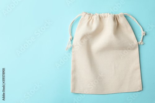 Cotton eco bag on light blue background, top view. Space for text