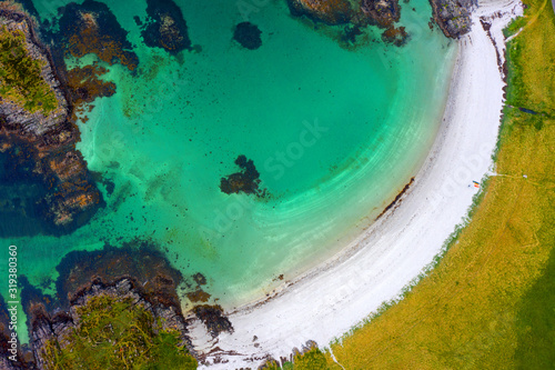 Fototapeta Naklejka Na Ścianę i Meble -  Drone footage of waves lapping up onto rocks in Portuairk Bay, Scotland
