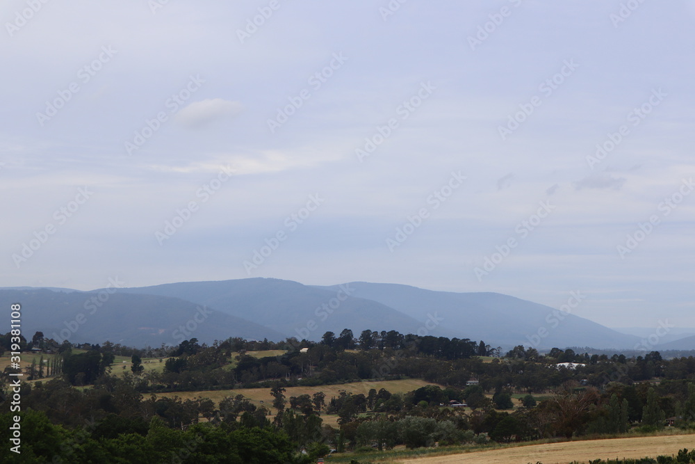 Mountains on the horizon with a cloudy backdrop.