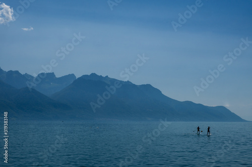 Paddle borders make their across Lake Geneva in the midst of deep summer