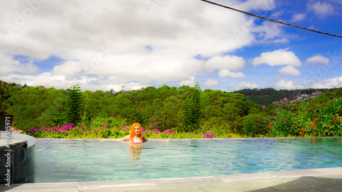  A young girl in the pool admires a beautiful view in the highlands in the city of Dalat.