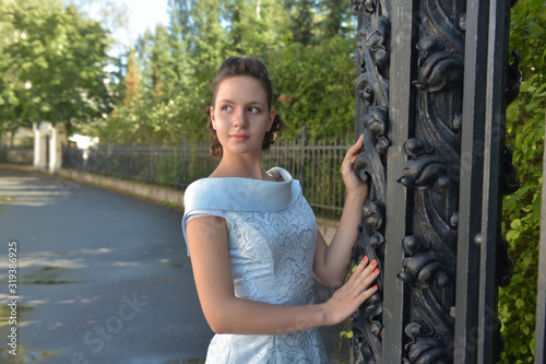 Beautiful brunette in pale blue evening dress outdoor. photo