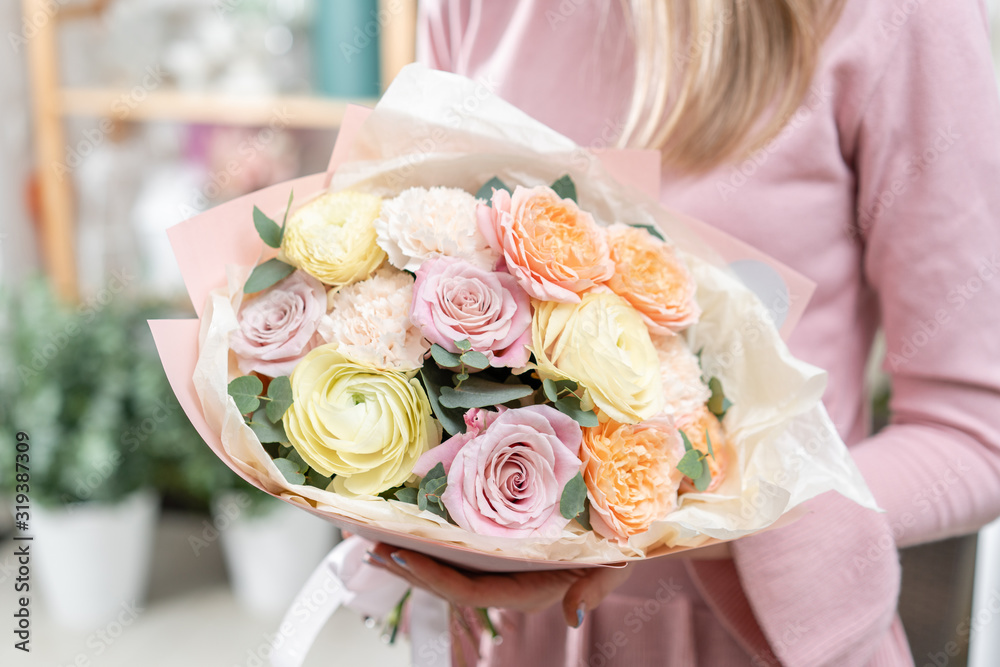 Beautiful bouquet in womans hands. the work of the florist at a flower shop. Delivery fresh cut flower. European floral shop.