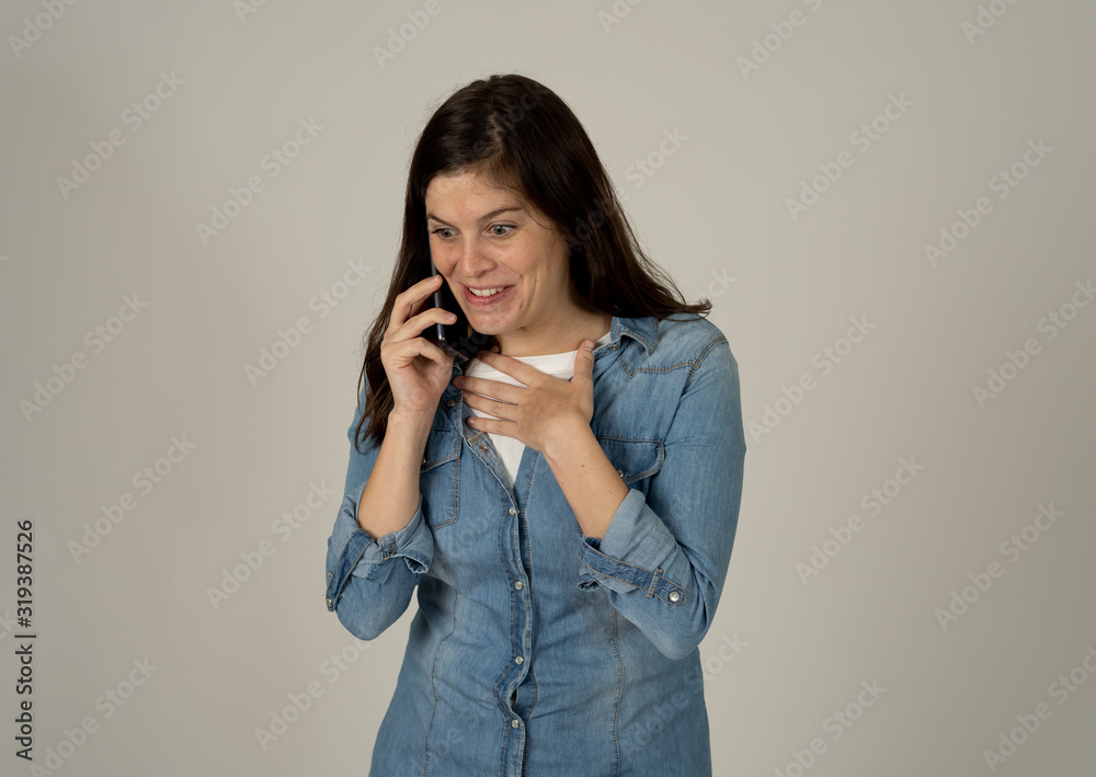 Attractive young woman talking and chatting on her smart phone isolated on gray background Attractive young woman talking and chatting on her smart phone isolated on gray background